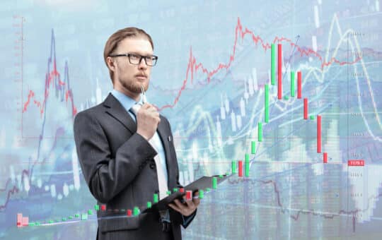 Businessman Trader Analyst In Glasses Spectacles With Notebook And Thinking, On Diagram Background. Trading On Stock Exchange Concept